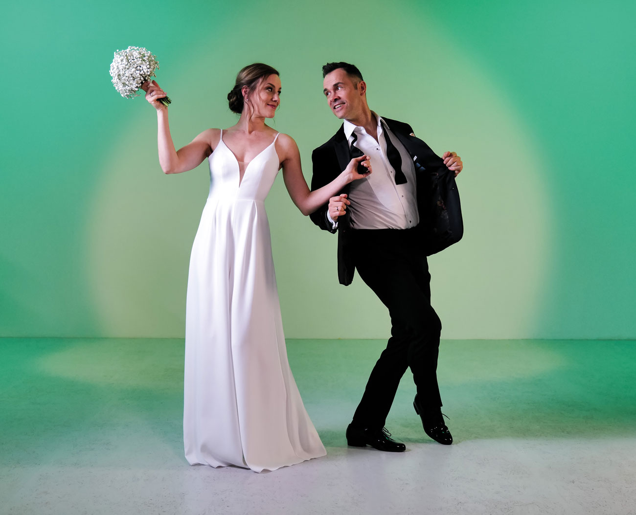 Junges Brautpaar in Brauttanzschuhen von Werner Kern Bridal vor grüner Studiowand