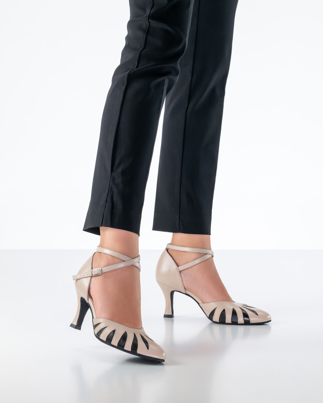 Una modelo con pantalones negros ajustados lleva unas zapatillas de baile cerradas de color beige del modelo «Donatella» de Werner Kern.