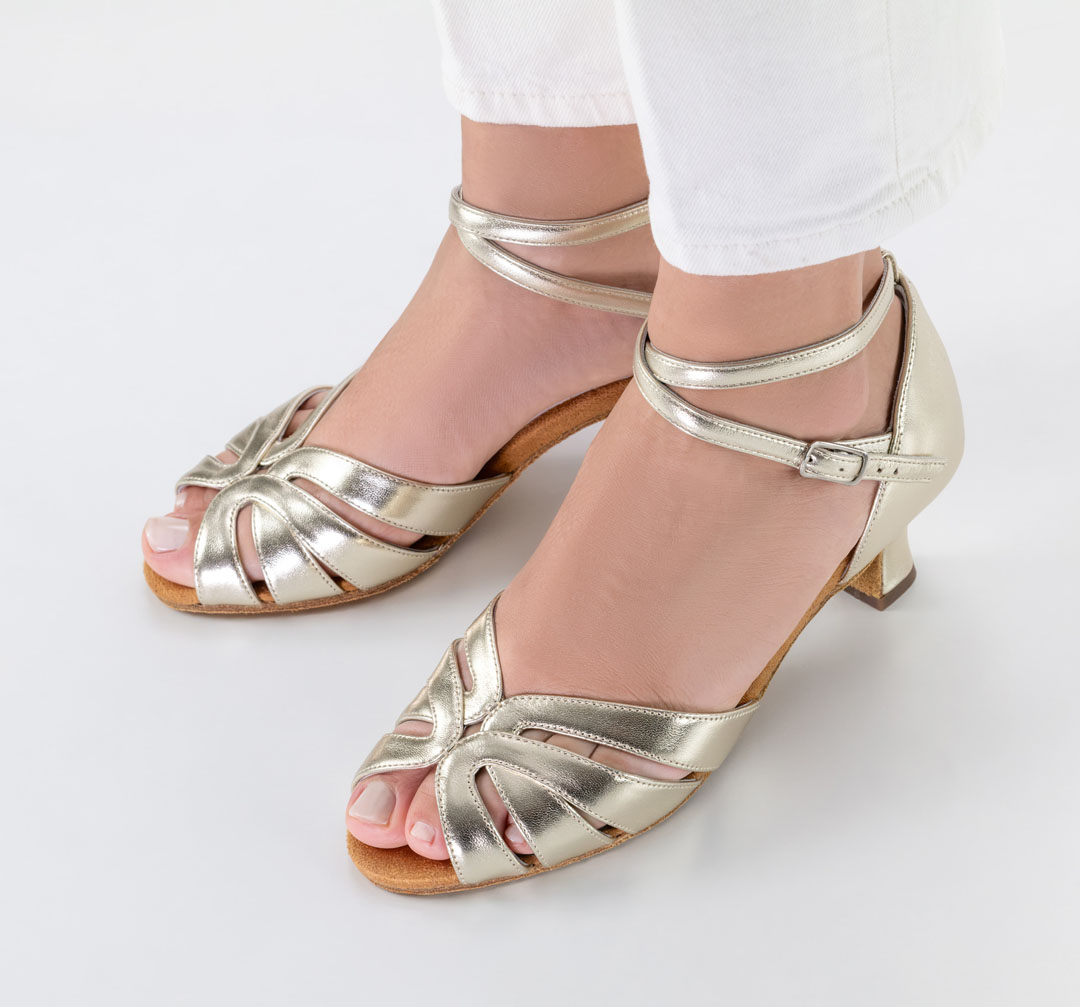 Sandalias de baile abiertas «Thea», de piel napa dorada con tacón acampanado de 5 cm, combinadas con unos vaqueros blancos de Werner Kern