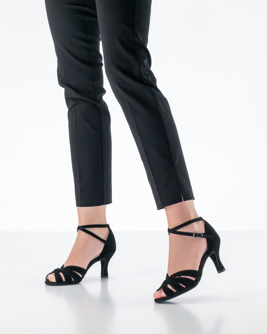 Sandalias negras de baile abiertas «Olympe» de Anna Kern, lucidas por una modelo con pantalones negros en el estudio
