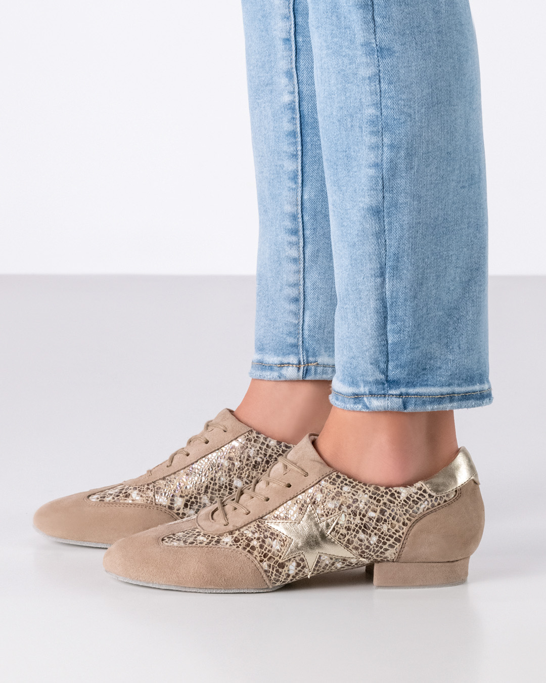 Zapatilla de baile con diseño tipo sneaker, suela plana y detalle de estrella dorada.