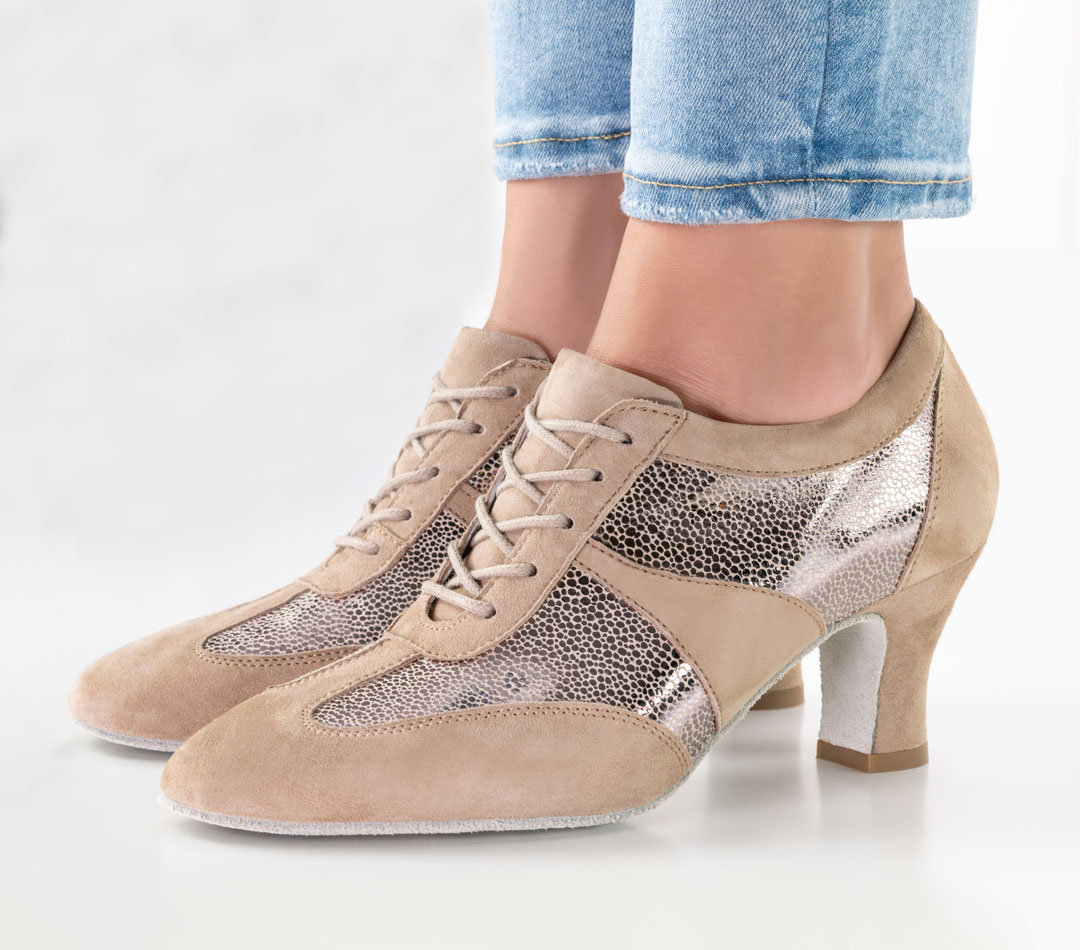 Primer plano de una modelo con vaqueros y zapatillas de baile de color beige con cordones y tacón de bloque de 6 cm