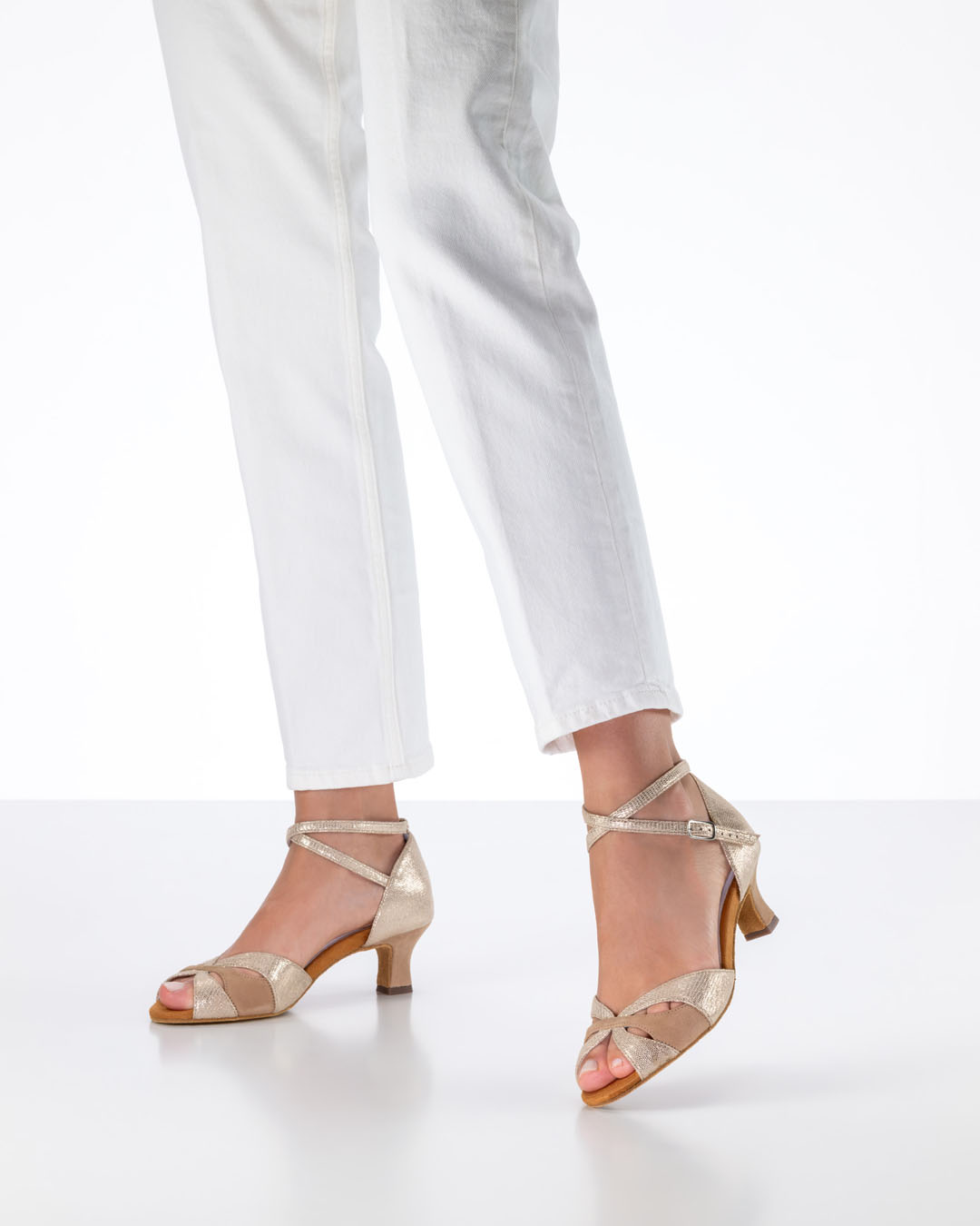 La modelo lleva unos vaqueros blancos y unas sandalias de baile de color beige «Eunice» de Anna Kern