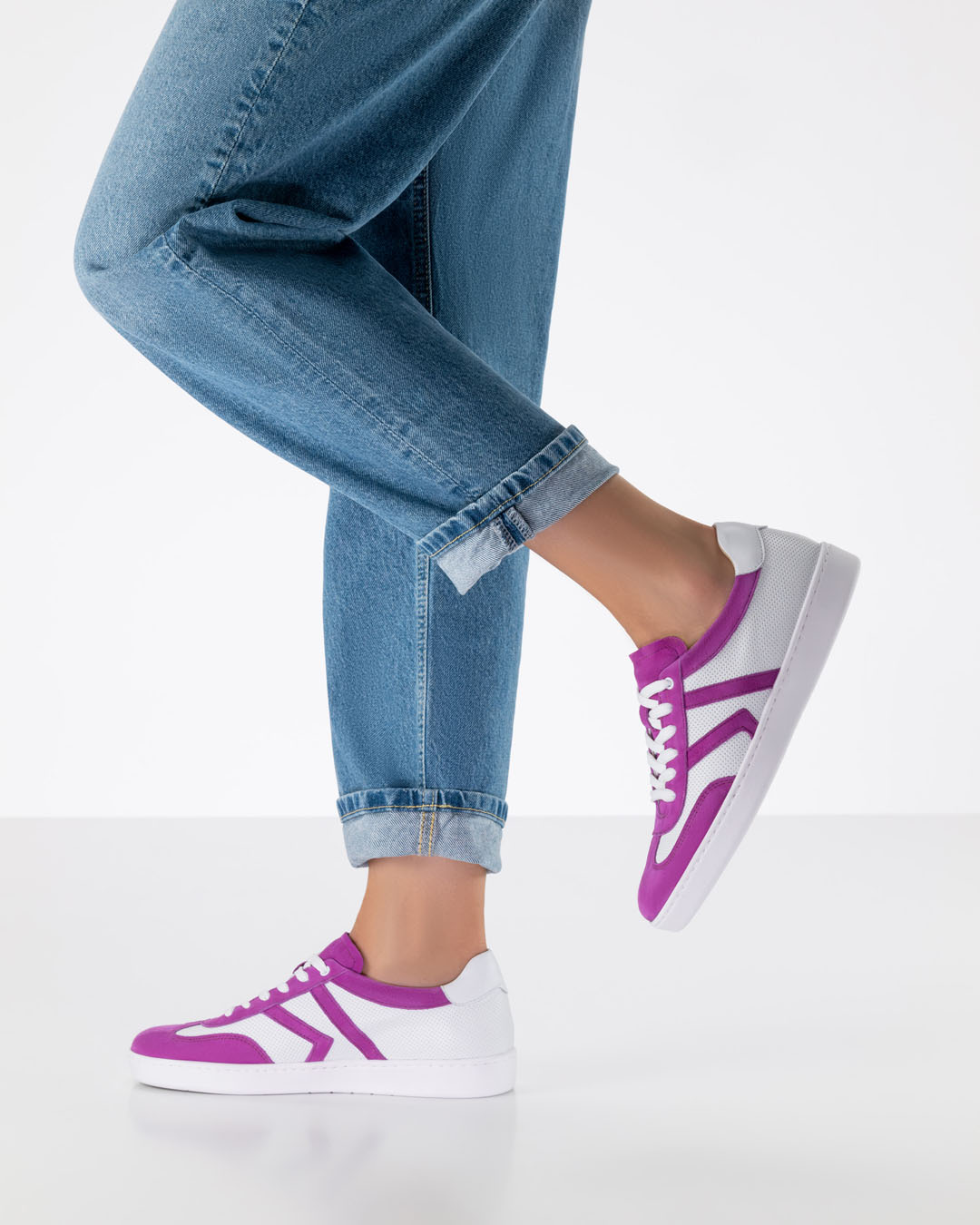 Modelo con vaqueros holgados y zapatillas de baile de cuero blanco con detalles en rosa