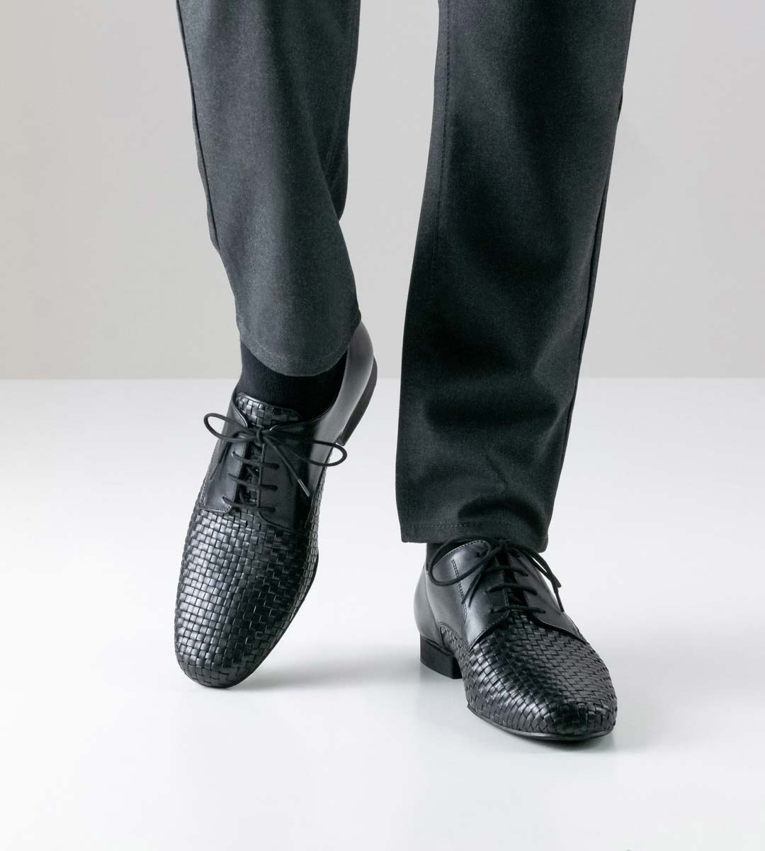 Como hand geflochtener schwarzer Herrentanzschuh in Kombination mit grauer Hose