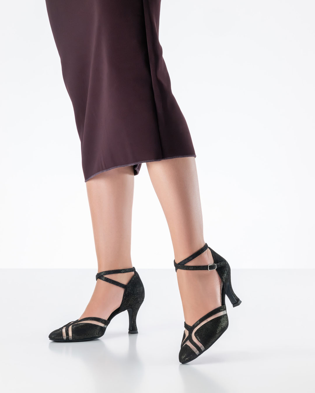 Modelo con un vestido ajustado de color rojo oscuro y zapatos de baile negros brillantes de Werner Kern, con tacón de 6,5 cm
